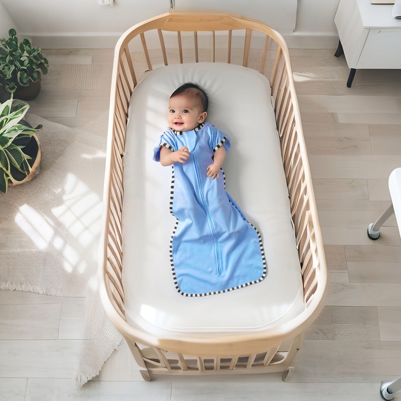 Queness Transition Swaddle on a sleeping newborn for cozy, secure rest.