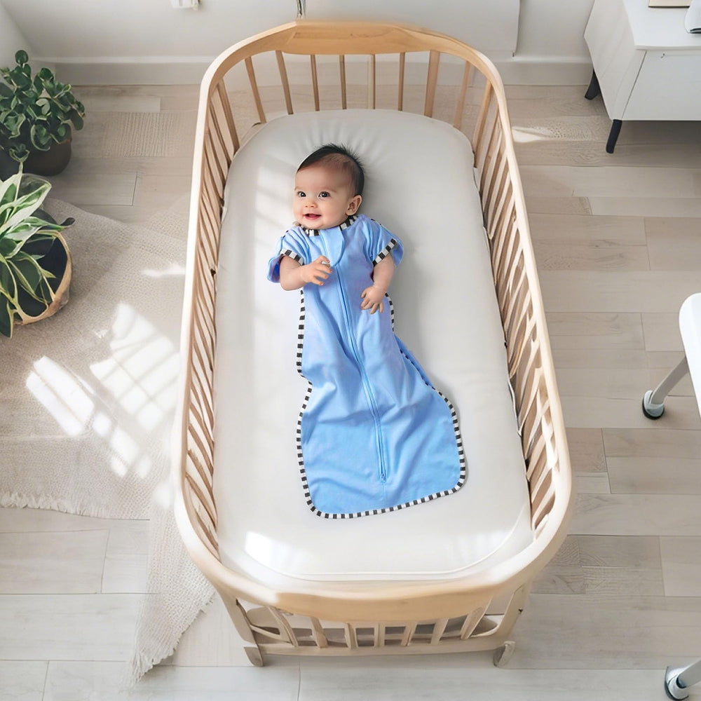 Queness Transition Swaddle on a sleeping newborn for cozy, secure rest.