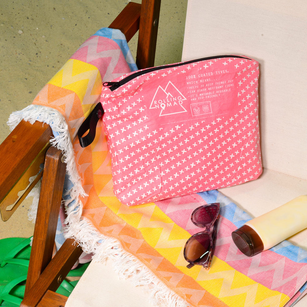 Rolling Nomad Tyvek pouch front pattern with radiant beach sunset design.