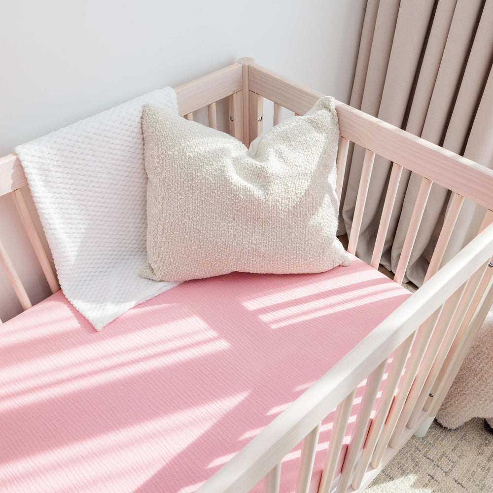 ROMY RO crib sheets show elastic snug-fit for wrinkle-free mattress coverage.