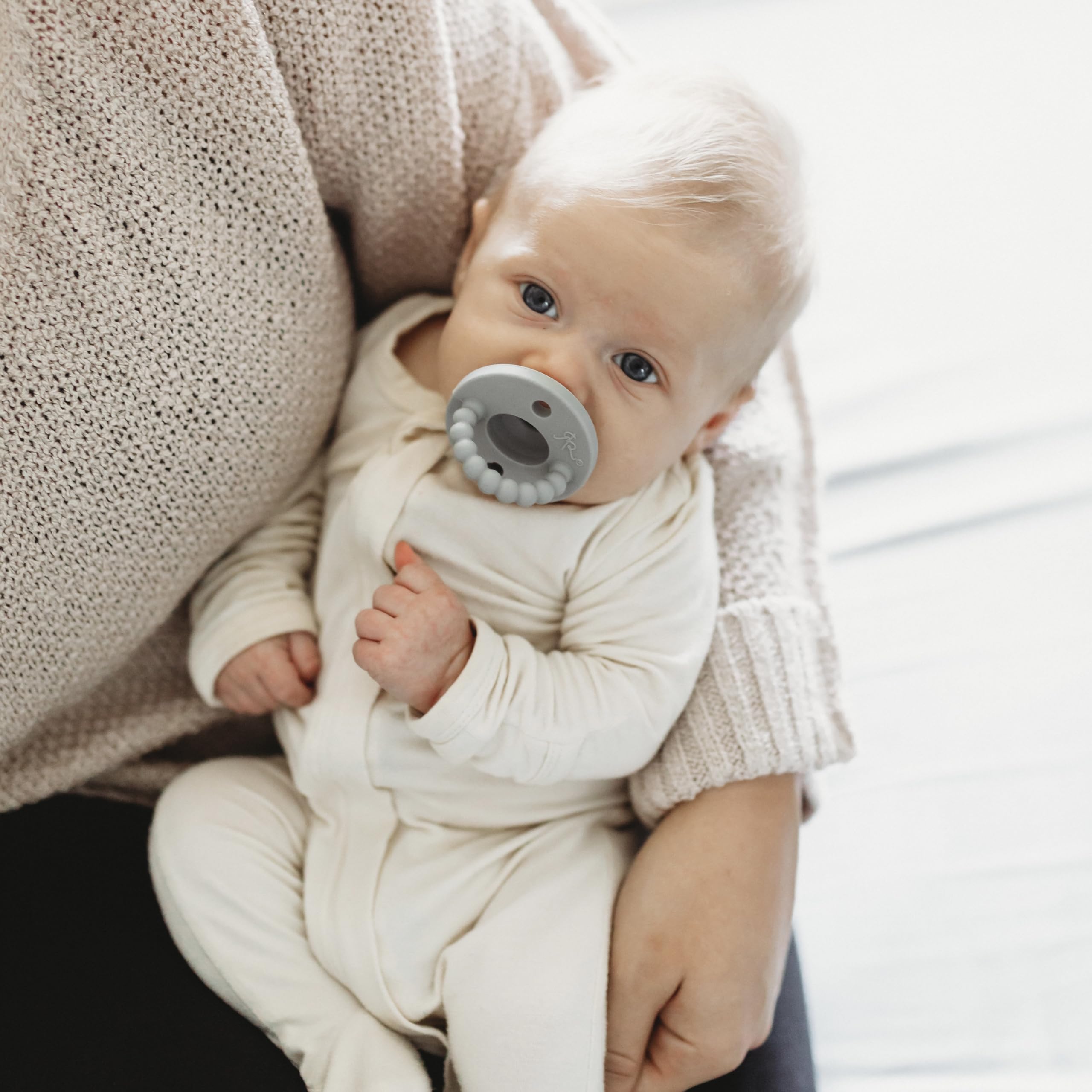 Ryan & Rose Cutie PAT baby holding pacifier during calm moments