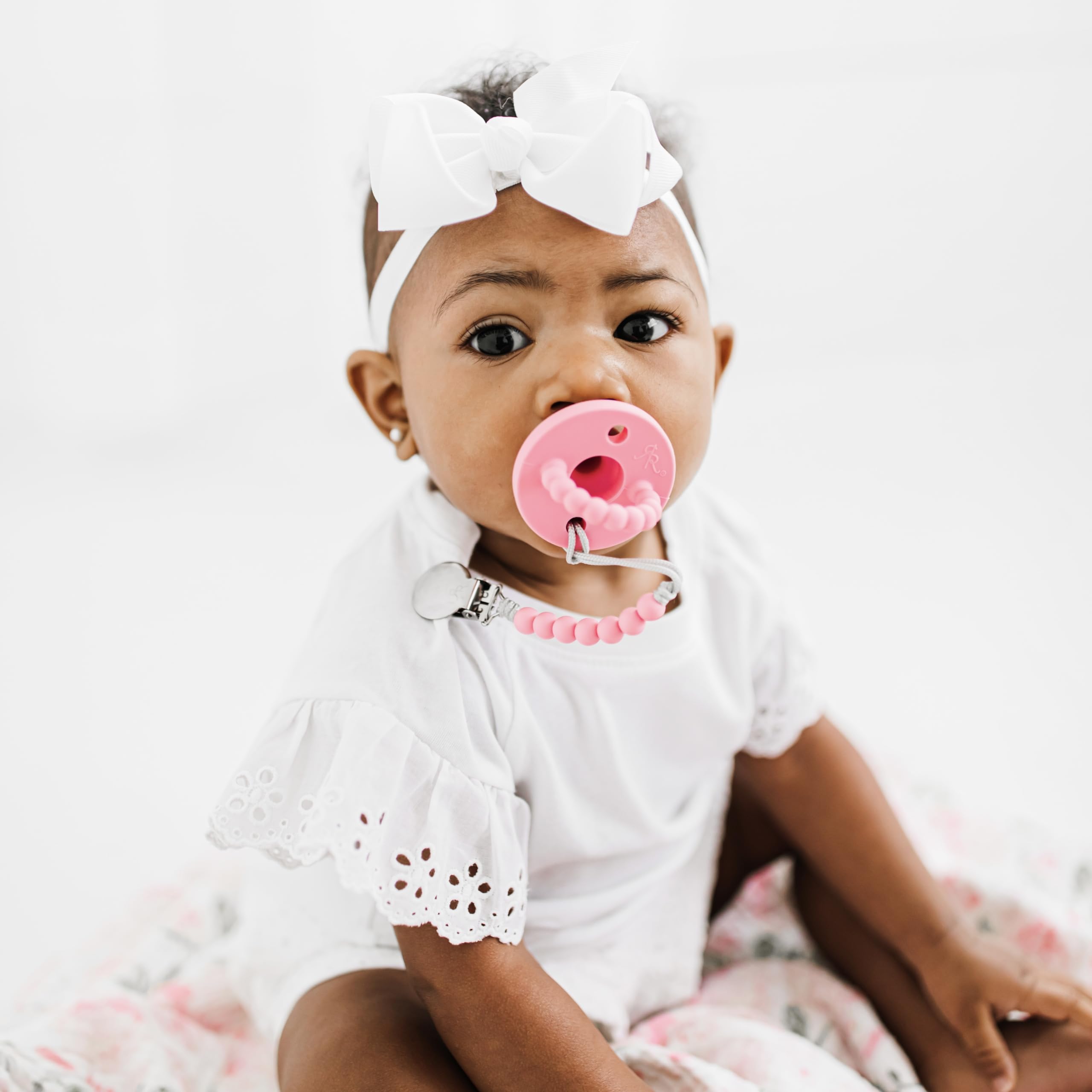 Ryan & Rose Cutie PAT Bliss baby using pacifier and teether on the go