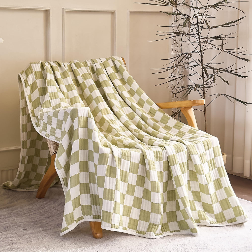 SANACYNA crib nursery scene with green grid blanket for all-season use.