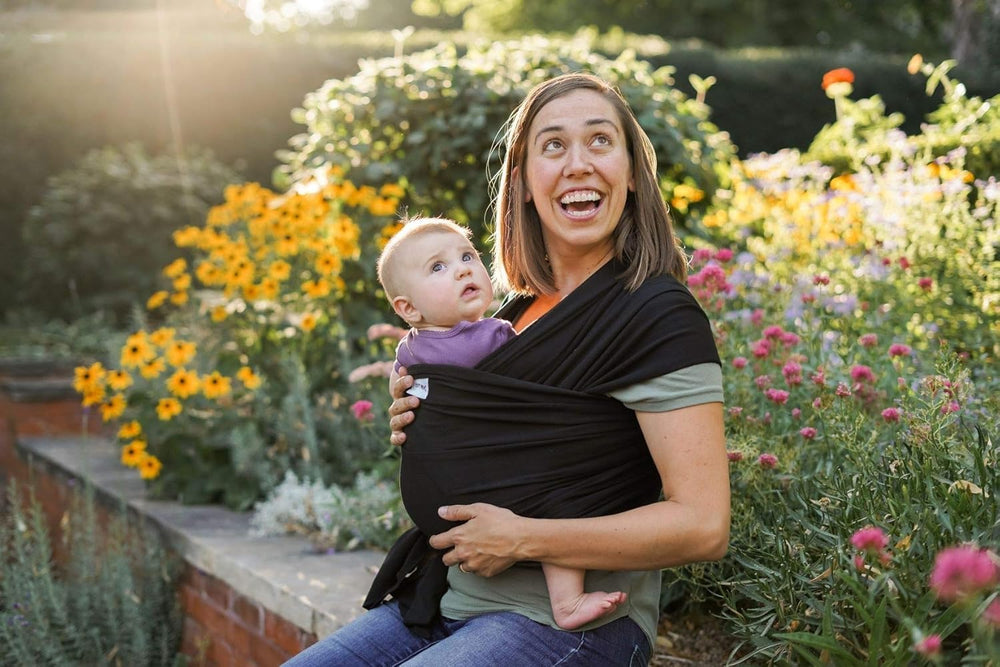 Sleepy Wrap chest carry with newborn close to caregiver's heart for bonding.
