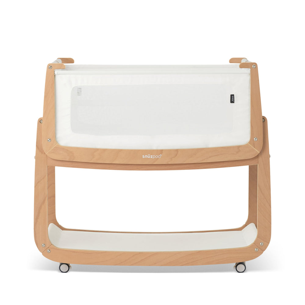 SnuzPod5 bedside bassinet assembly beside bed for easy nighttime access.