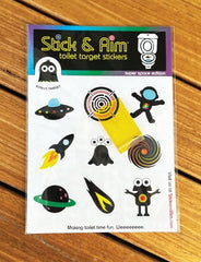 Stick & Aim toilet target on ceramic tile demonstrates space-themed design for aim practice.