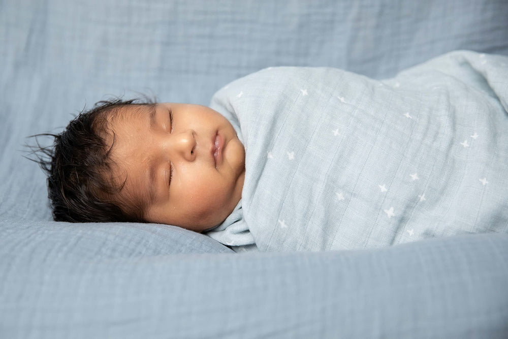 Sticky Toffee Muslin Swaddle soft texture in hand highlighting lightweight weave.