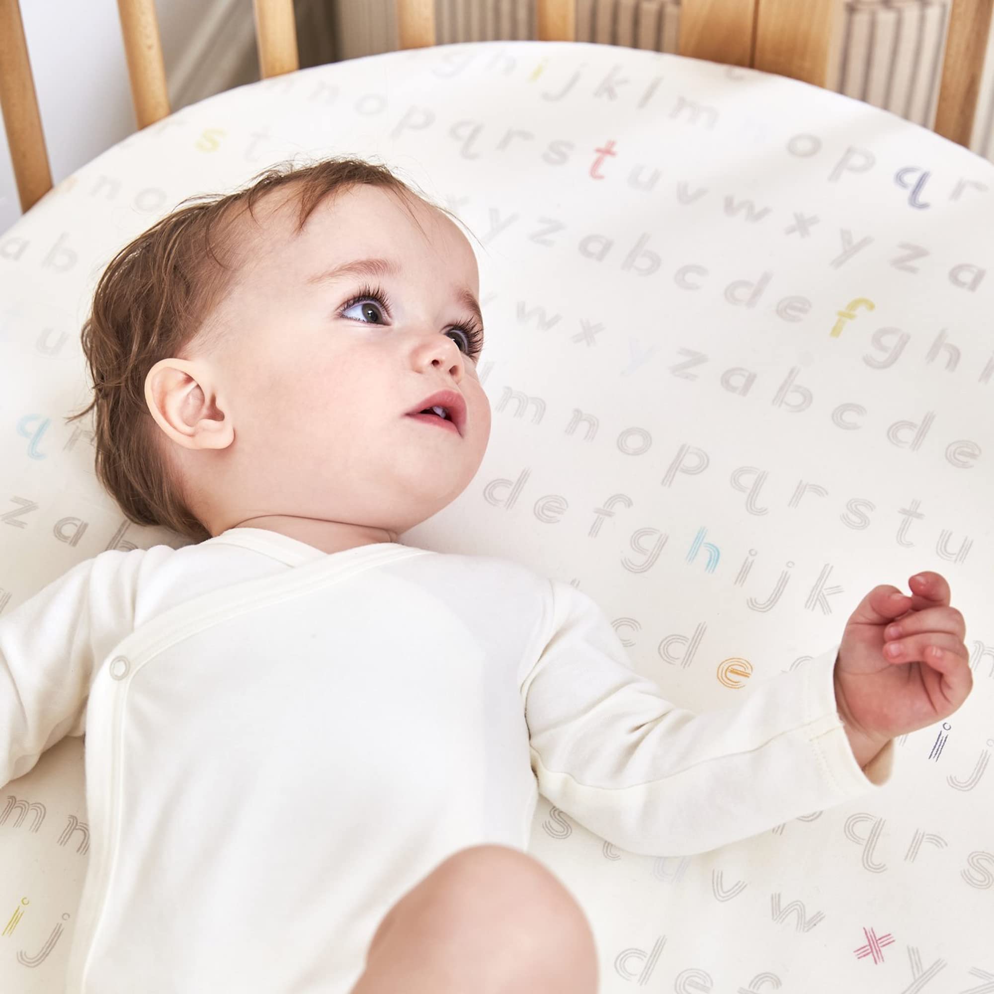 Stokke Sleepi Mini fitted sheet Rainbow Dot adds playful nursery style.