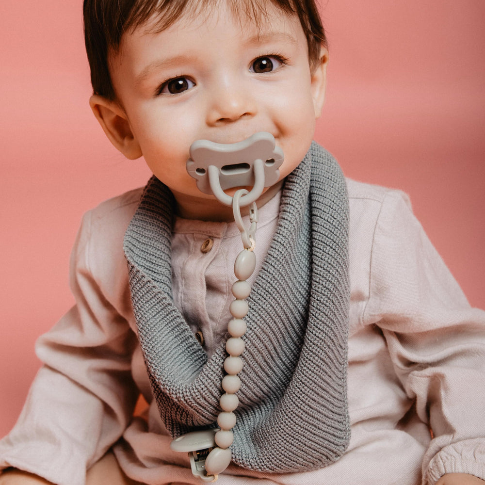 Suavinex green SX PRO pacifier in baby's hand suggests soothing accessibility.