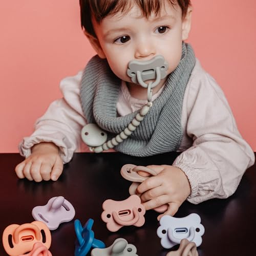 Suavinex Color Essence green pacifier beside bottle range for seamless transitions.