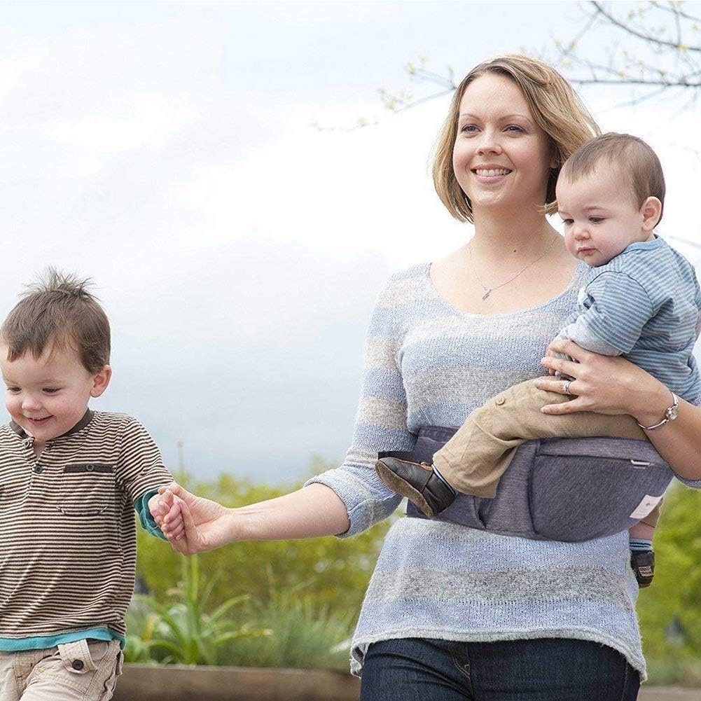 Sunnors baby carrier worn by caregiver illustrating hands-free use at home.