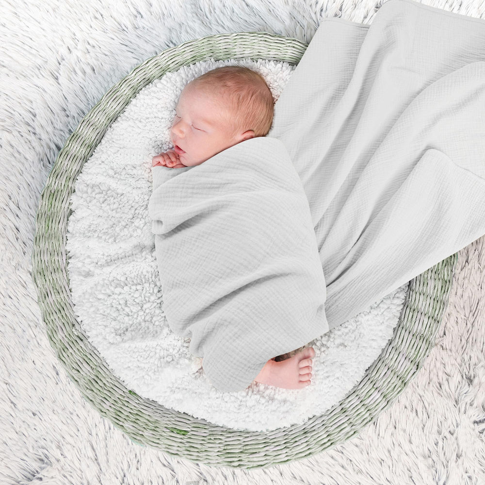 Susurration muslin blanket wrapped newborn demonstrating secure cozy wrap