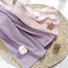 Susurration muslin swaddle blanket pink-purple baby sleep helper in lightweight breathable fabric.