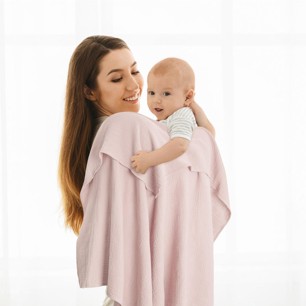 Susurration muslin swaddle blanket pink-purple used as burp cloth or towel in everyday care.