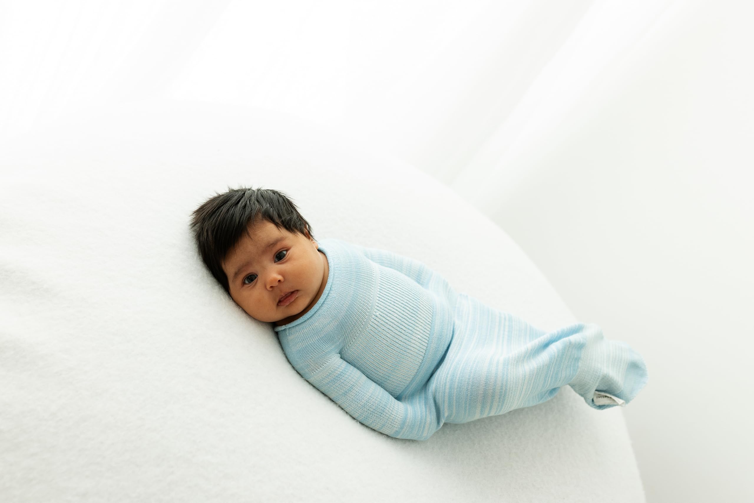 Swaddelini Swaddle Sleep Sack Blue in-use image depicts snug fit for baby relaxation.