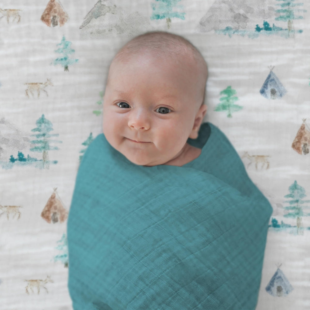 SwaddleDesigns Oceana muslin swaddle blanket edge-label closeup showing 123 steps.