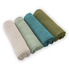 SwaddleDesigns Oceana muslin swaddle blanket on baby, highlighting breathable comfort.