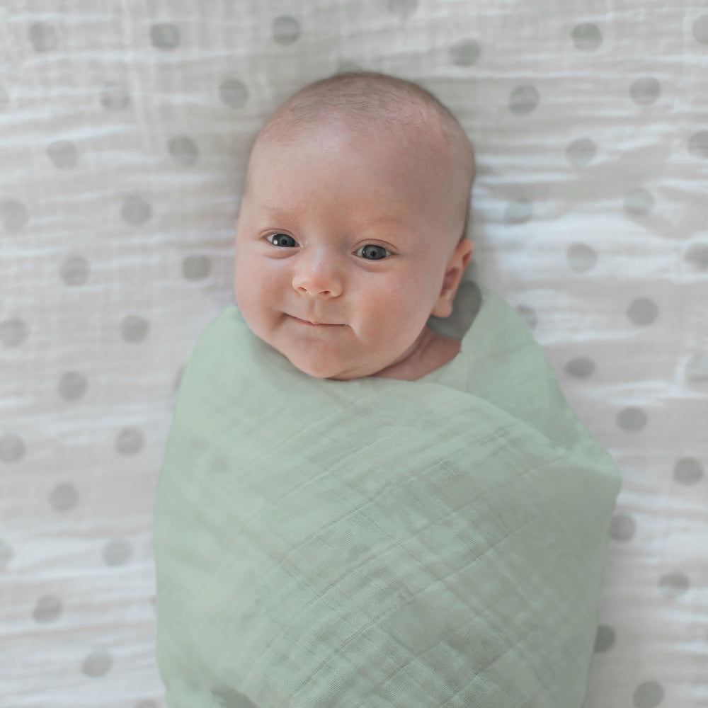 SwaddleDesigns Oceana muslin swaddle blanket during tummy time for comfy play.