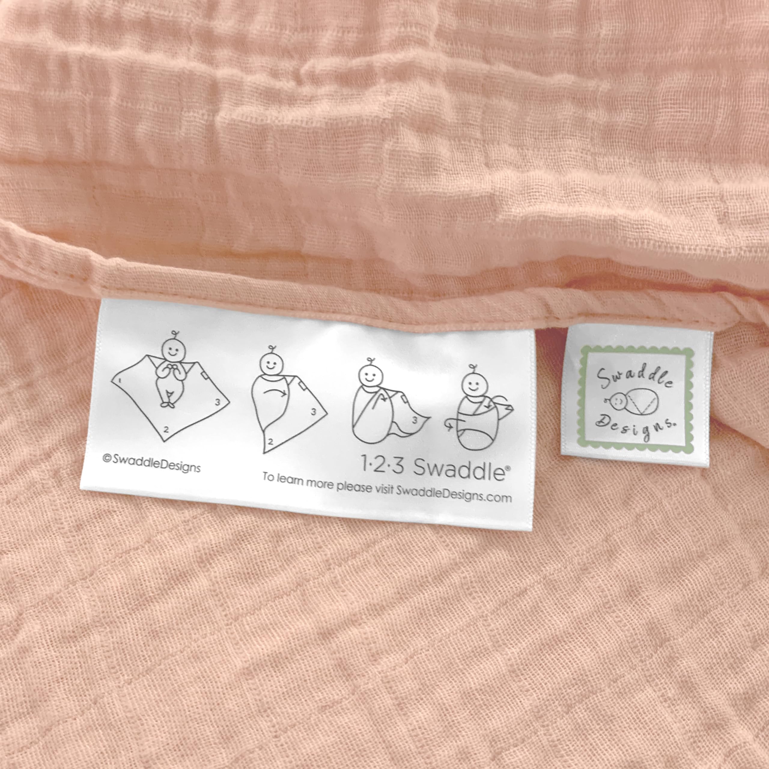 SwaddleDesigns Peach Blush blanket edge label shows easy swaddle steps