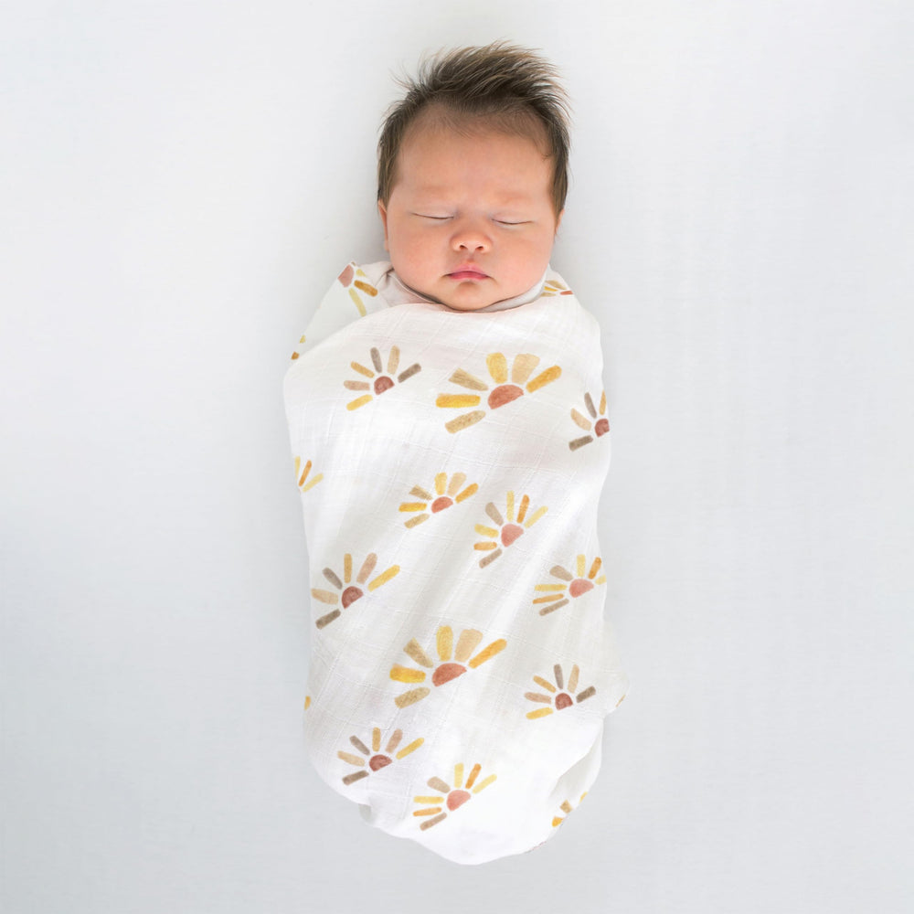 SwaddleDesigns watercolor sunny days edge label shows easy how-to-swaddle instructions