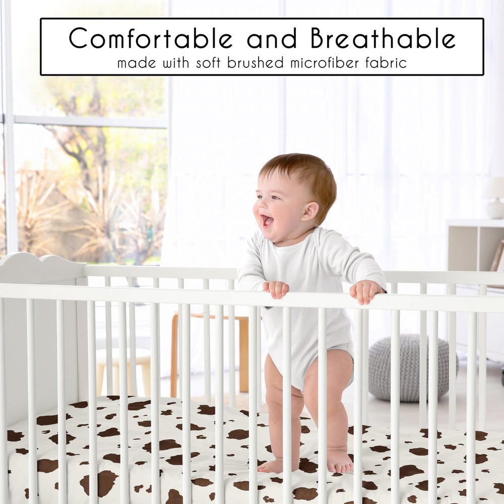 Sweet Jojo Designs cow print fitted crib sheet shown on a crib for snug fit.