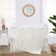 Sweet Jojo Designs off-white crib blanket with macrame trim for cozy nursery decor.