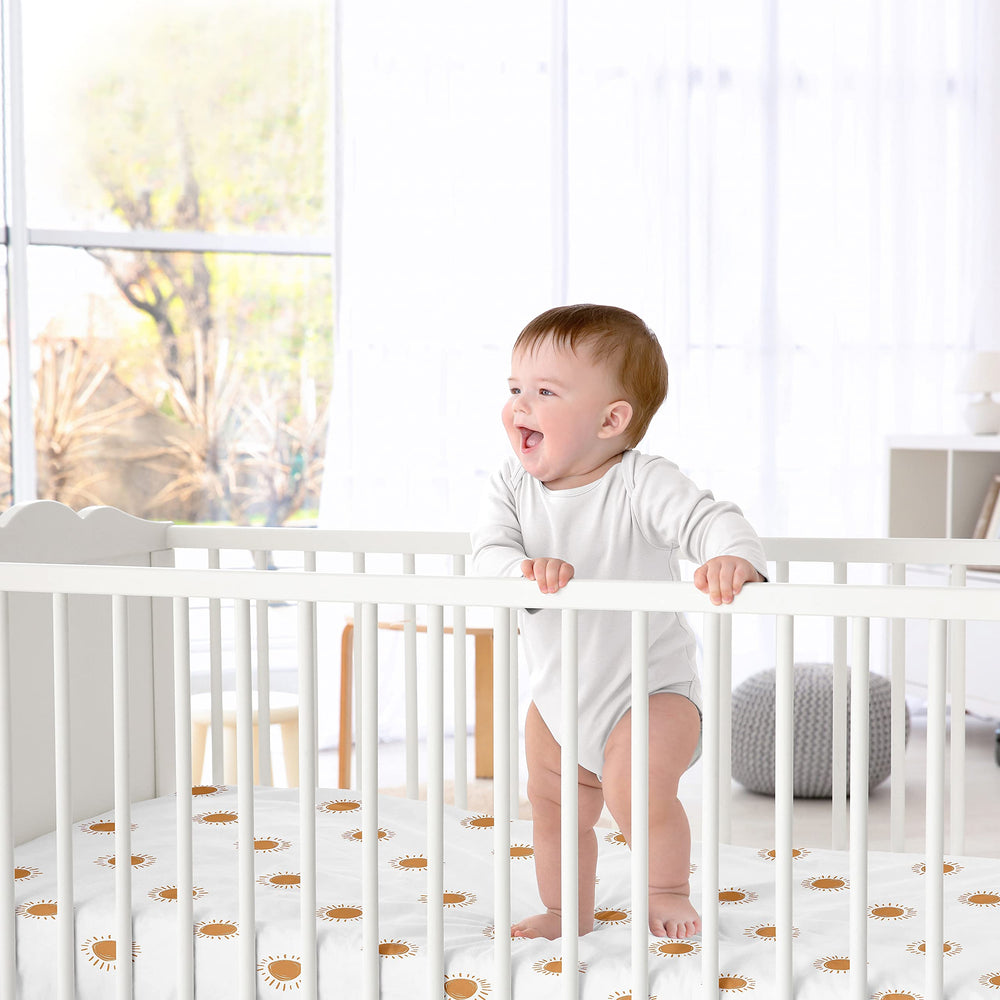 Sweet Jojo Designs orange-white boho sun satin sheet showcased in nursery setting