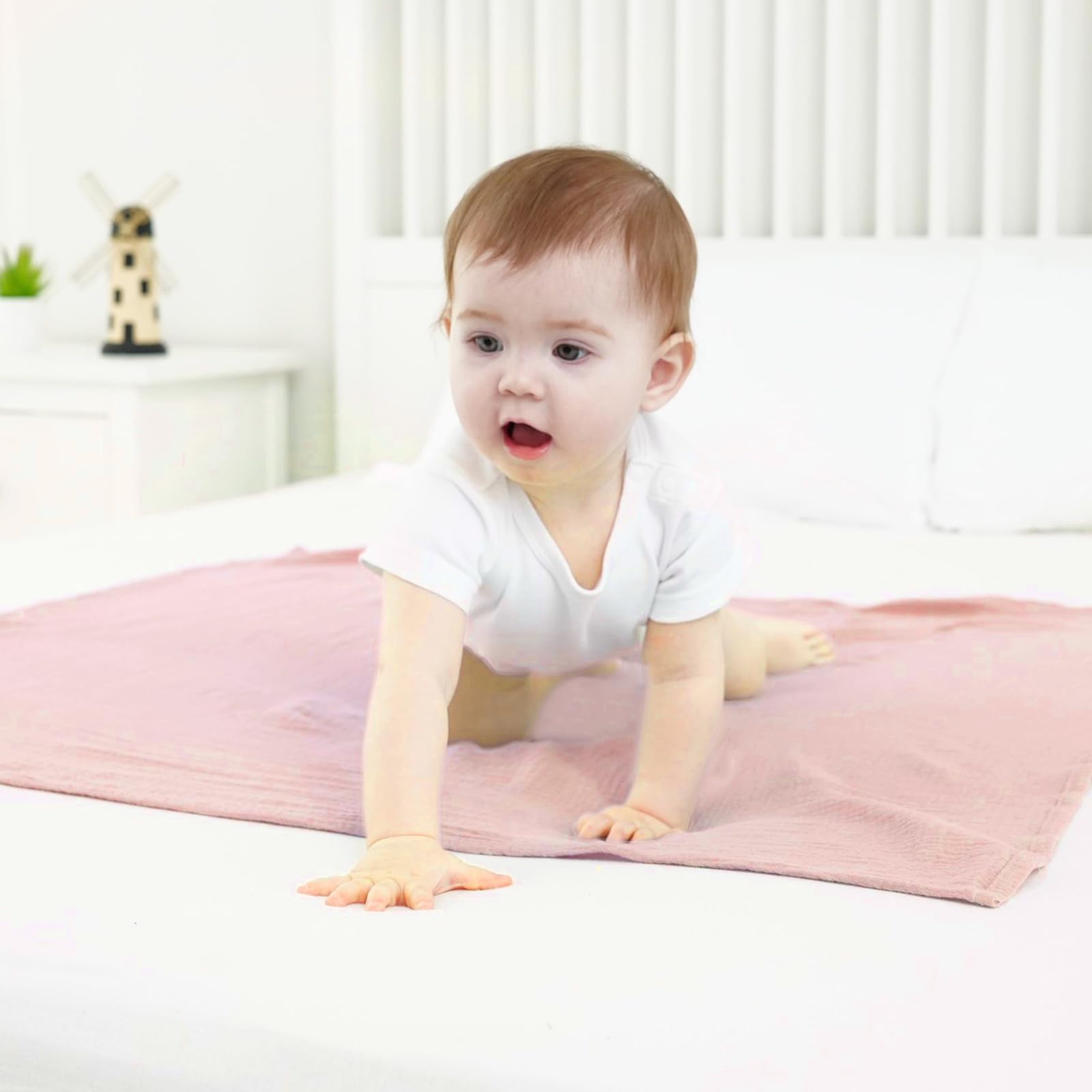 Synrroe muslin swaddle blanket 40x40 inches floral pink, folded to reveal breathable layers for year-round comfort.