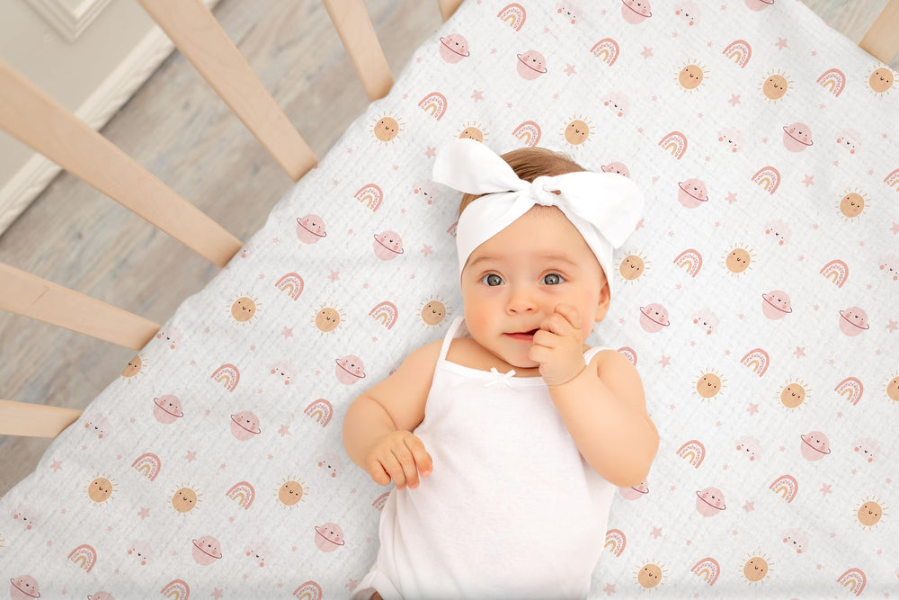 TADO MUSLIN pink-pattern crib sheet folded emphasizes cozy, double-layer fabric for year-round comfort.