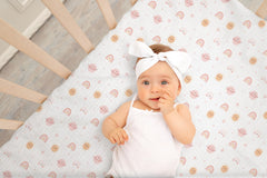 TADO MUSLIN pink-pattern crib sheet folded emphasizes cozy, double-layer fabric for year-round comfort.