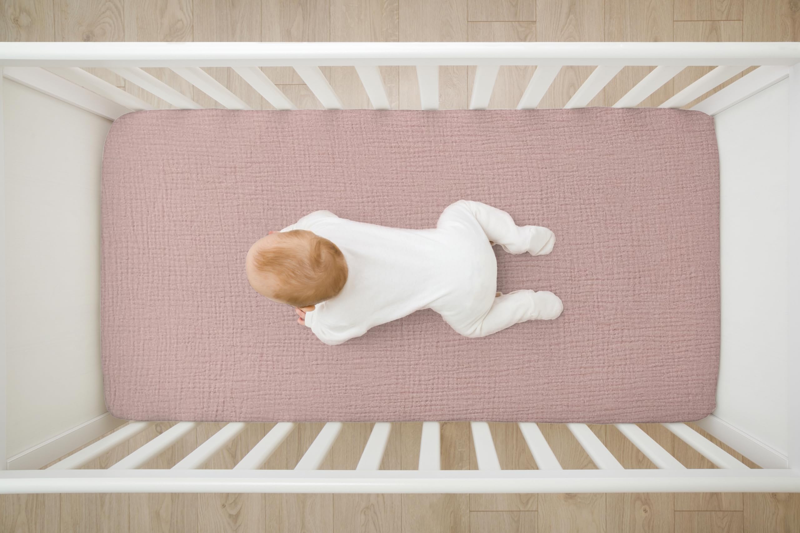 TADO MUSLIN pink-pattern crib sheet on mattress showing deep pockets for secure tuck.