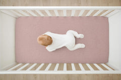 TADO MUSLIN pink-pattern crib sheet on mattress showing deep pockets for secure tuck.