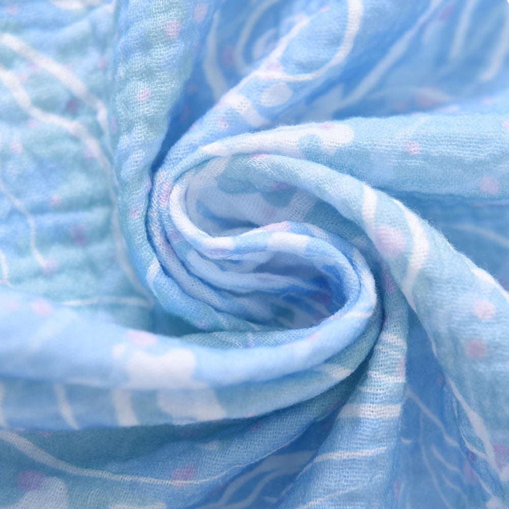 TADO MUSLIN crib sheet soft texture against baby's skin close-up