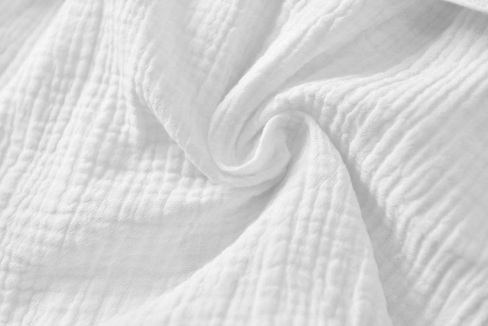TADO MUSLIN size-label close-up, preshrunk organic cotton assurance.