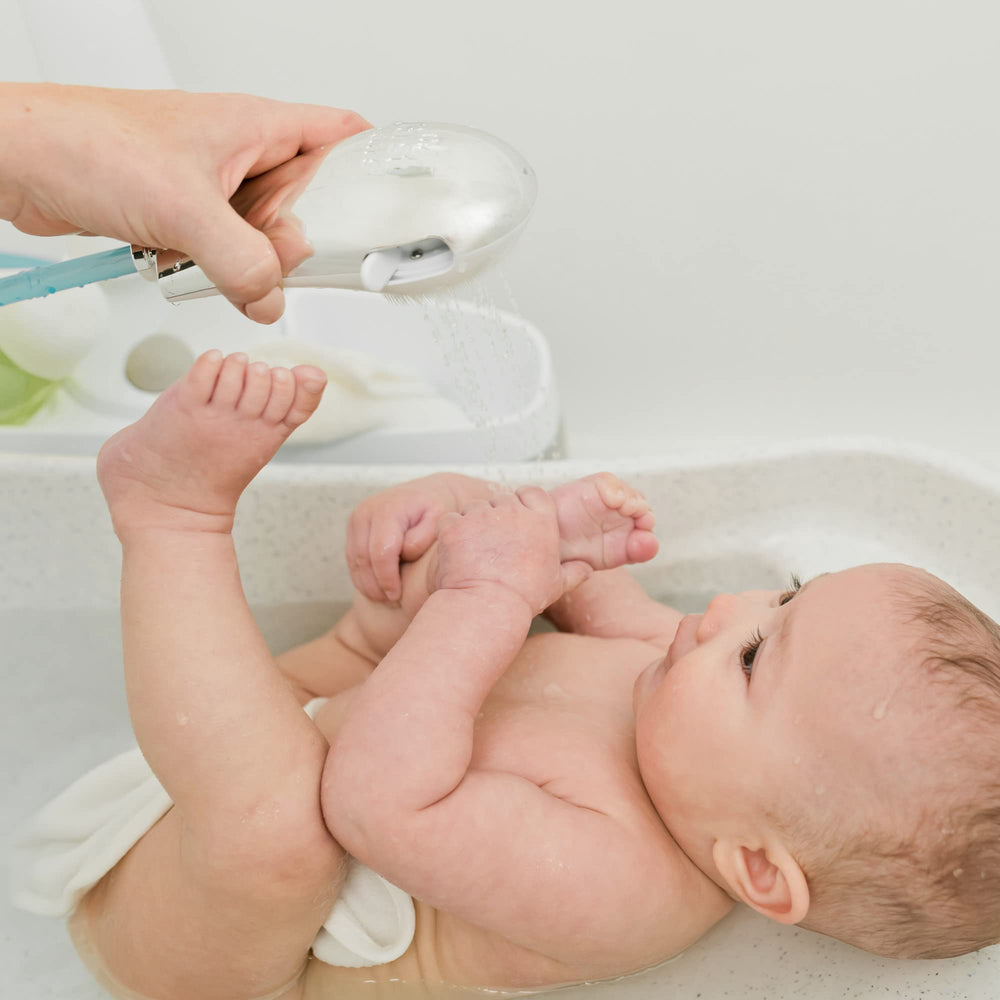 The First Years Rain Shower Head built-in brush offers a calming scrub during bath time.