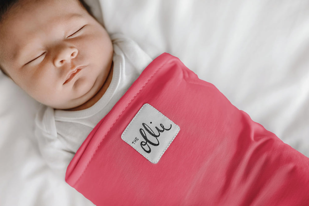 The Ollie Swaddle adjustable-closure highlights customizable fit for growing newborns.