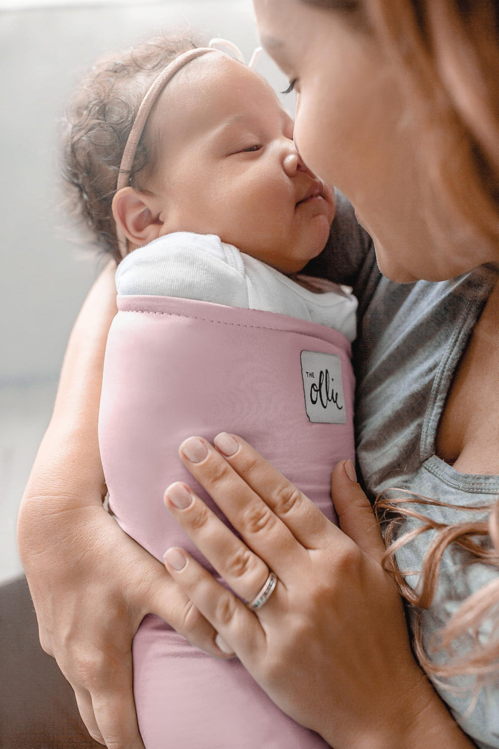 The Ollie Swaddle shows a calm newborn sleeping scene and soothing comfort.