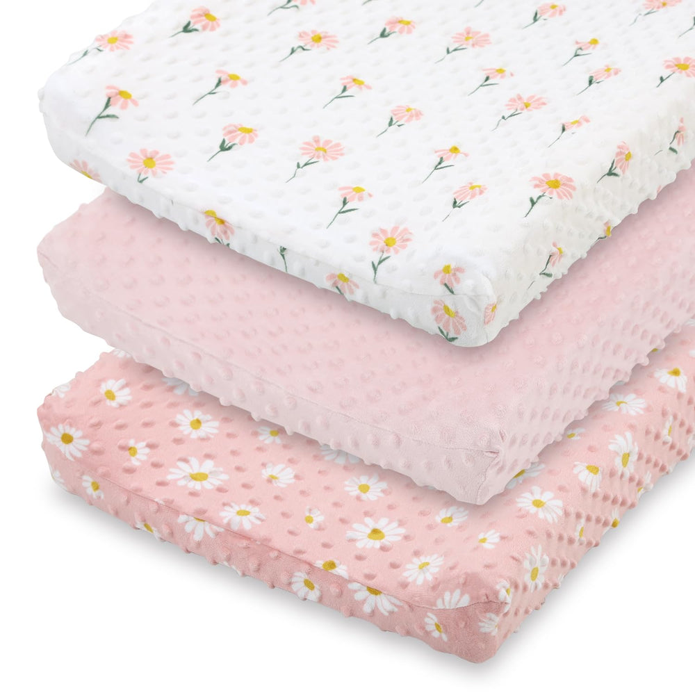 The Peanutshell daisy floral changing pad cover in pink keeps diaper changes cozy.