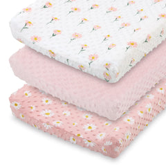 The Peanutshell daisy floral changing pad cover in pink keeps diaper changes cozy.