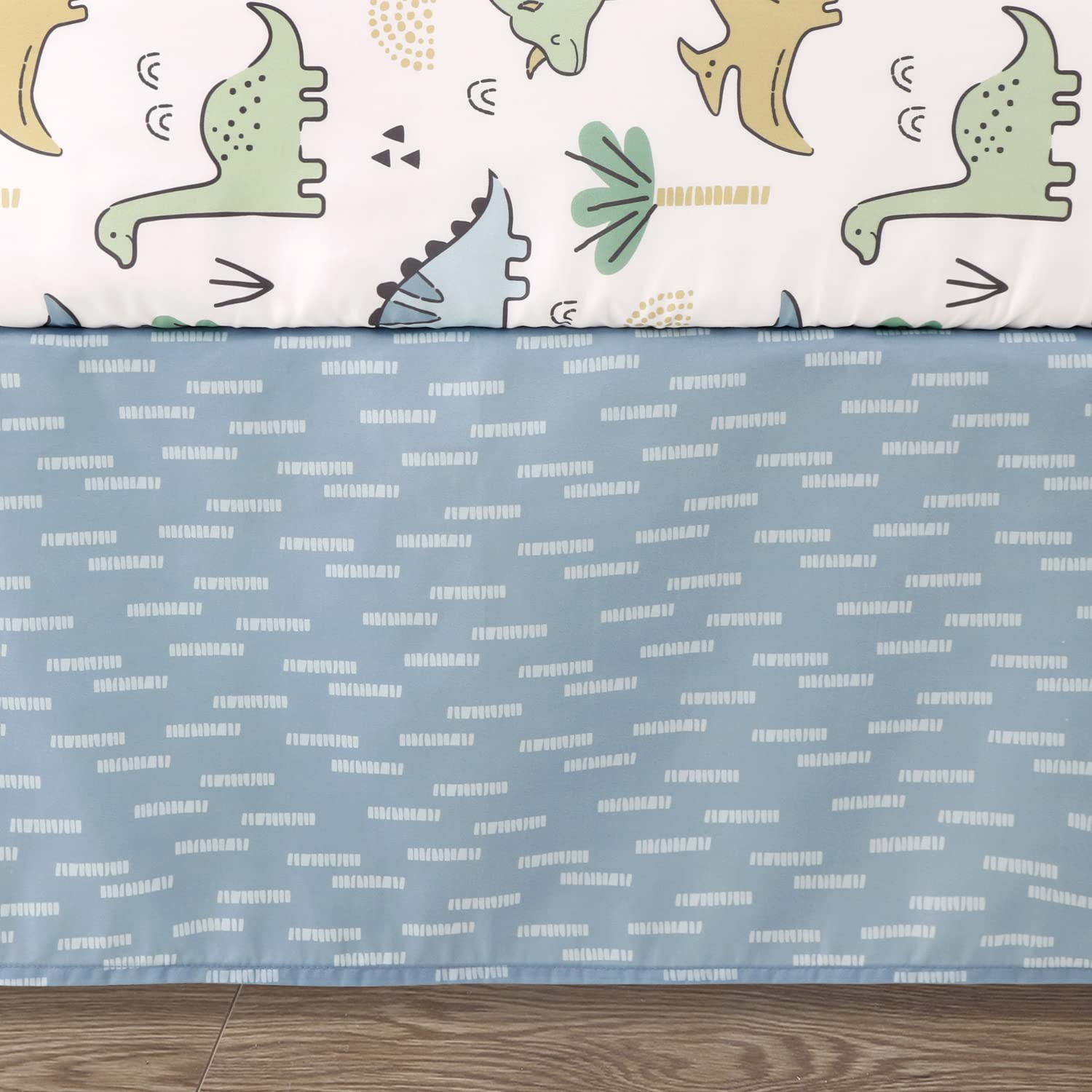 The Peanutshell blue dino dust ruffle finishes the crib look with tidy detail.
