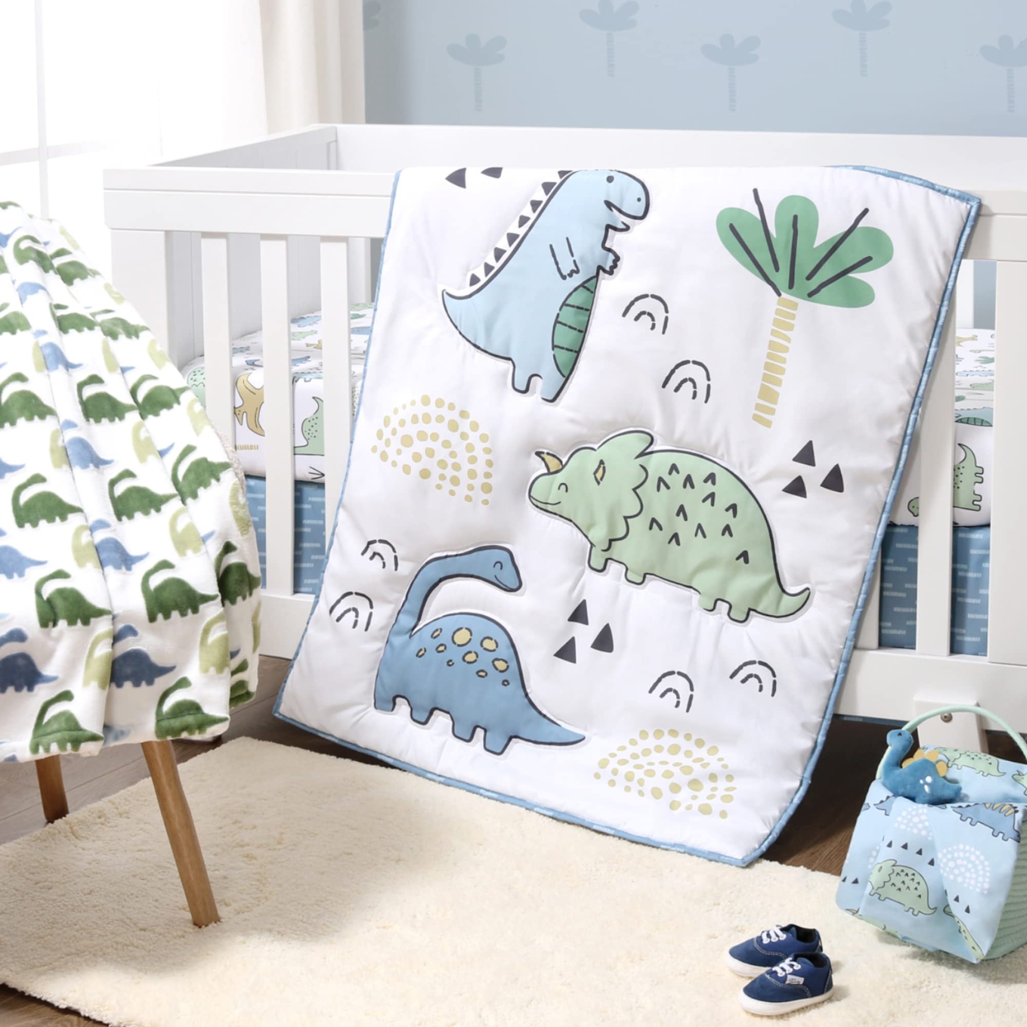 The Peanutshell blue dino quilt offers cozy bedtime comfort for baby naps.