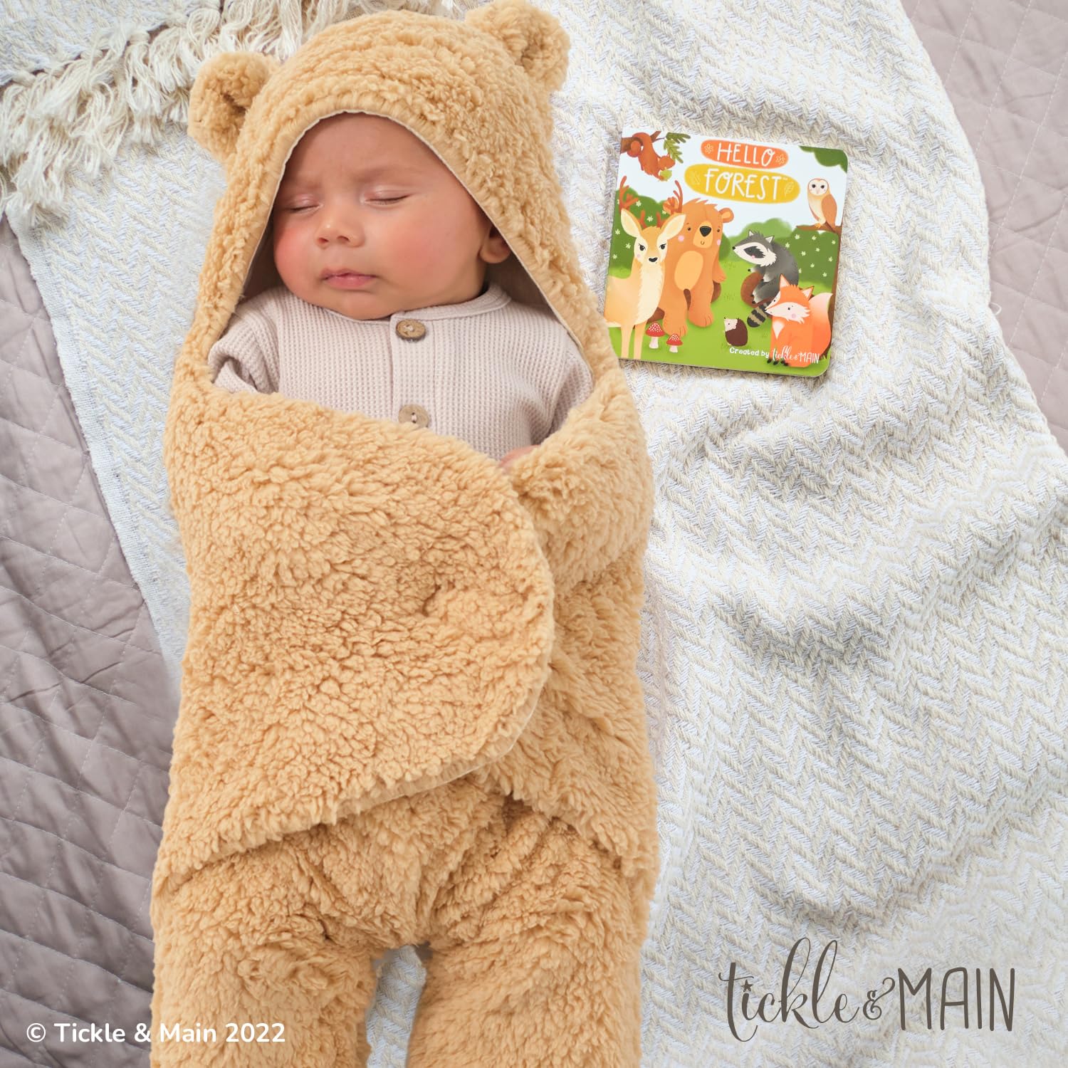 Tickle & Main forest storybook open pages invite curious baby and caregiver reading.