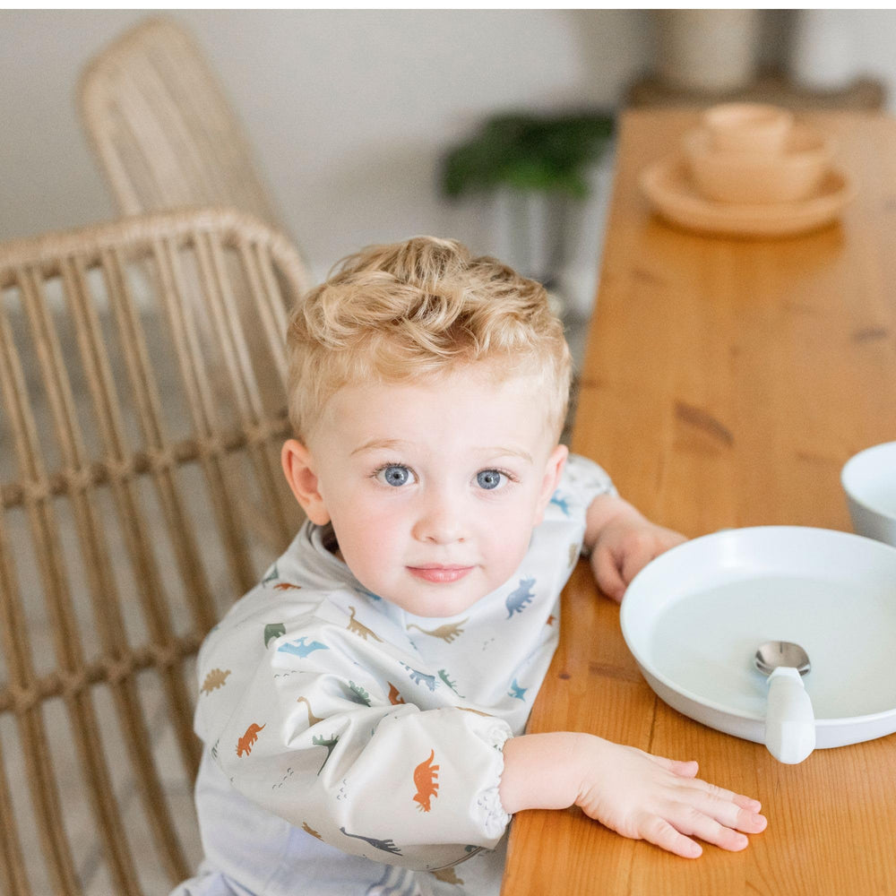 Tiny Twinkle elastic-cuff bib close-up shows comfortable, mess-free wear during feeding
