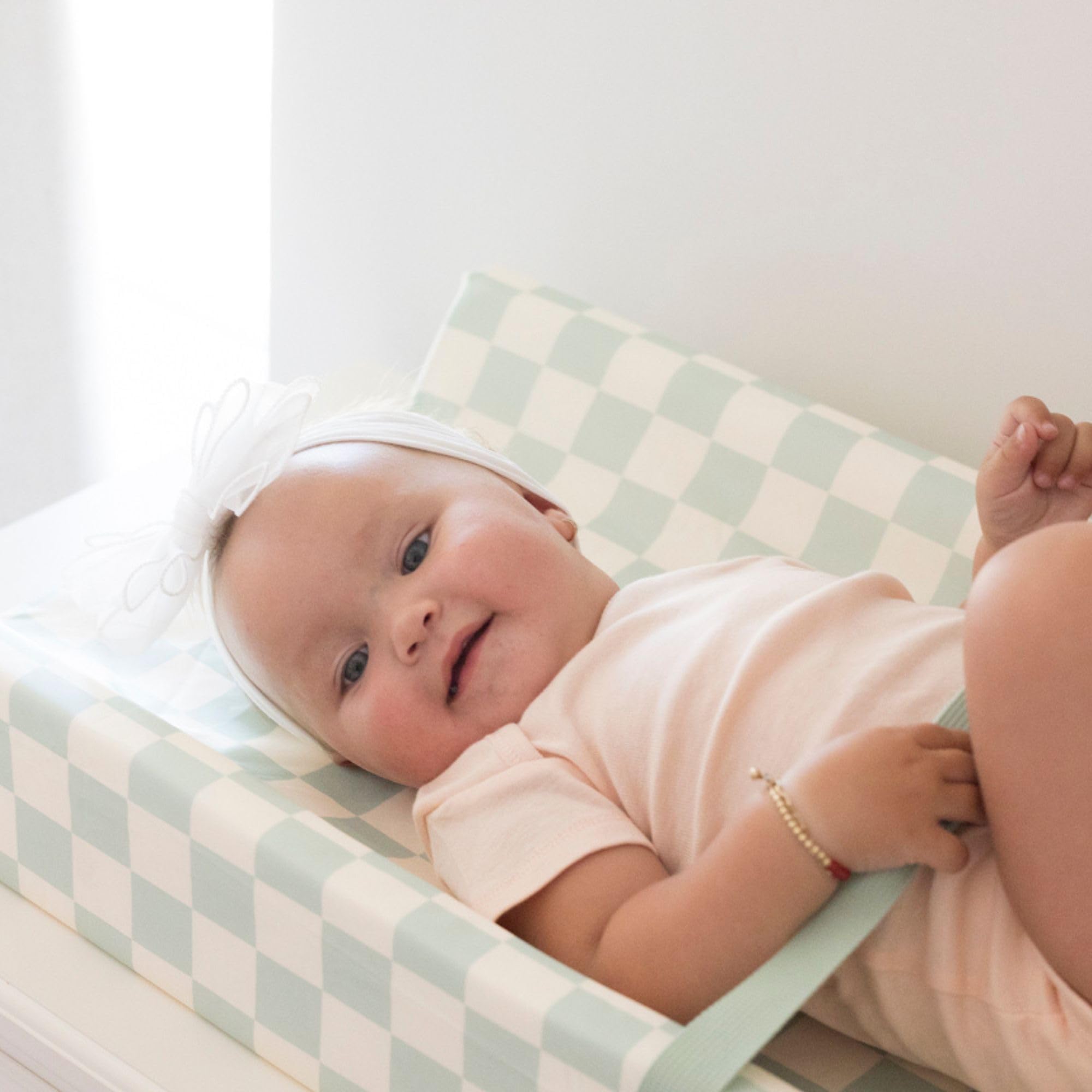 Tiny Twinkle contoured foam cushions baby safely during diaper changes.