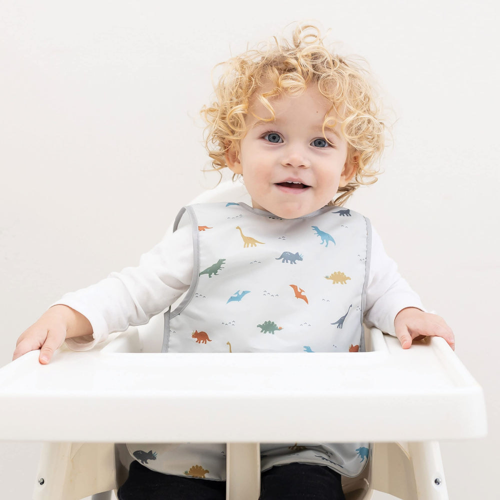 Tiny Twinkle dinosaur bib back view highlights waterproof barrier for spills.