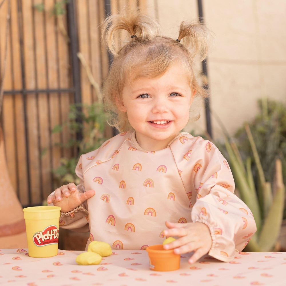 Tiny Twinkle long-sleeve bib closeup of waterproof fabric demonstrating spill protection during meals.