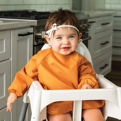 Tiny Twinkle long-sleeve bib sand cinnamon full-coverage design keeps kids clean during snacks and meals.