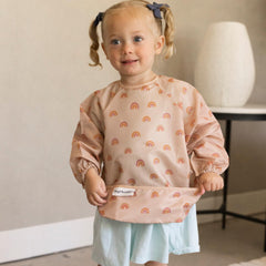Tiny Twinkle long-sleeve bib worn on baby with elastic cuffs for full-body coverage.