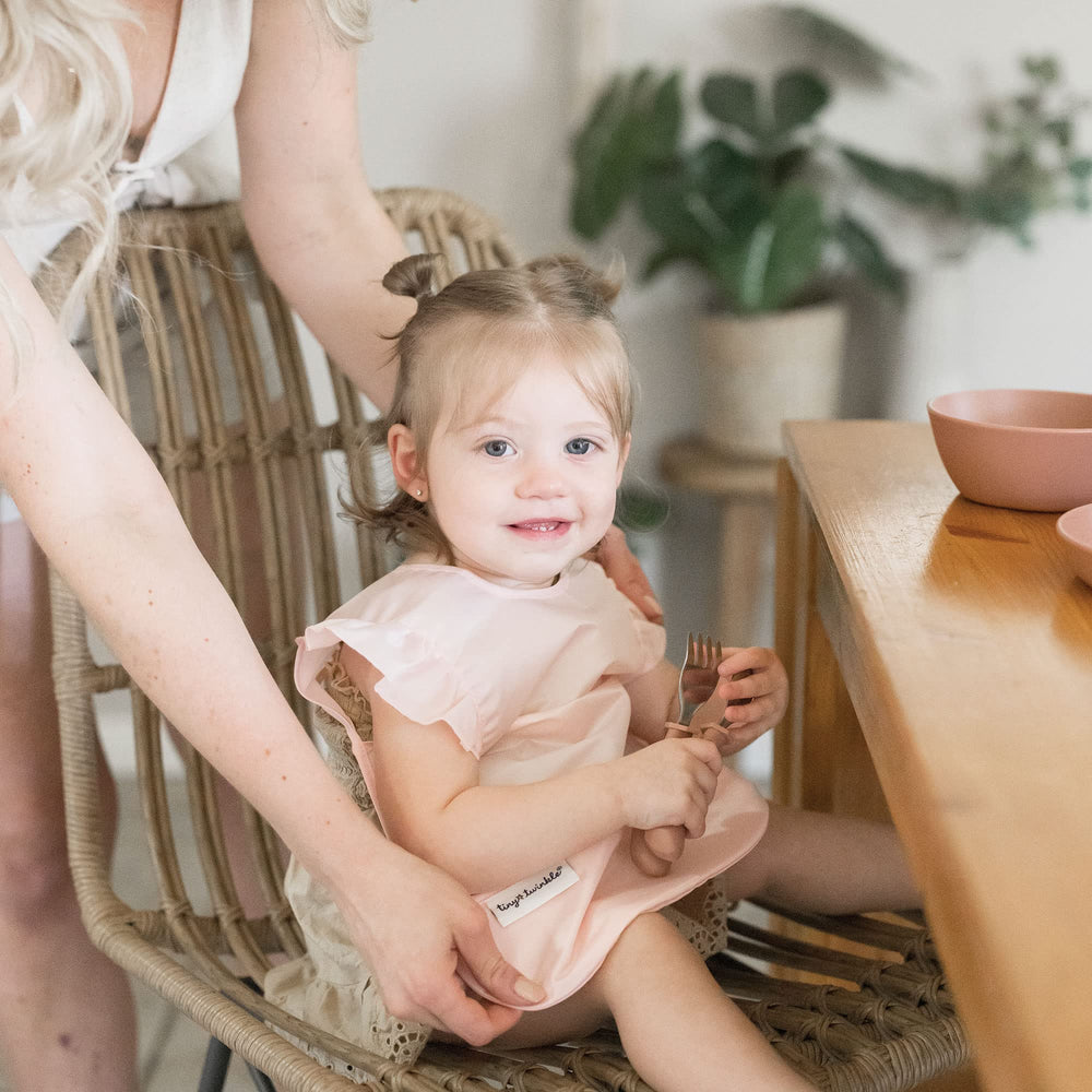 Tiny Twinkle machine-washable baby bib rose laundry-ready after messy meals.