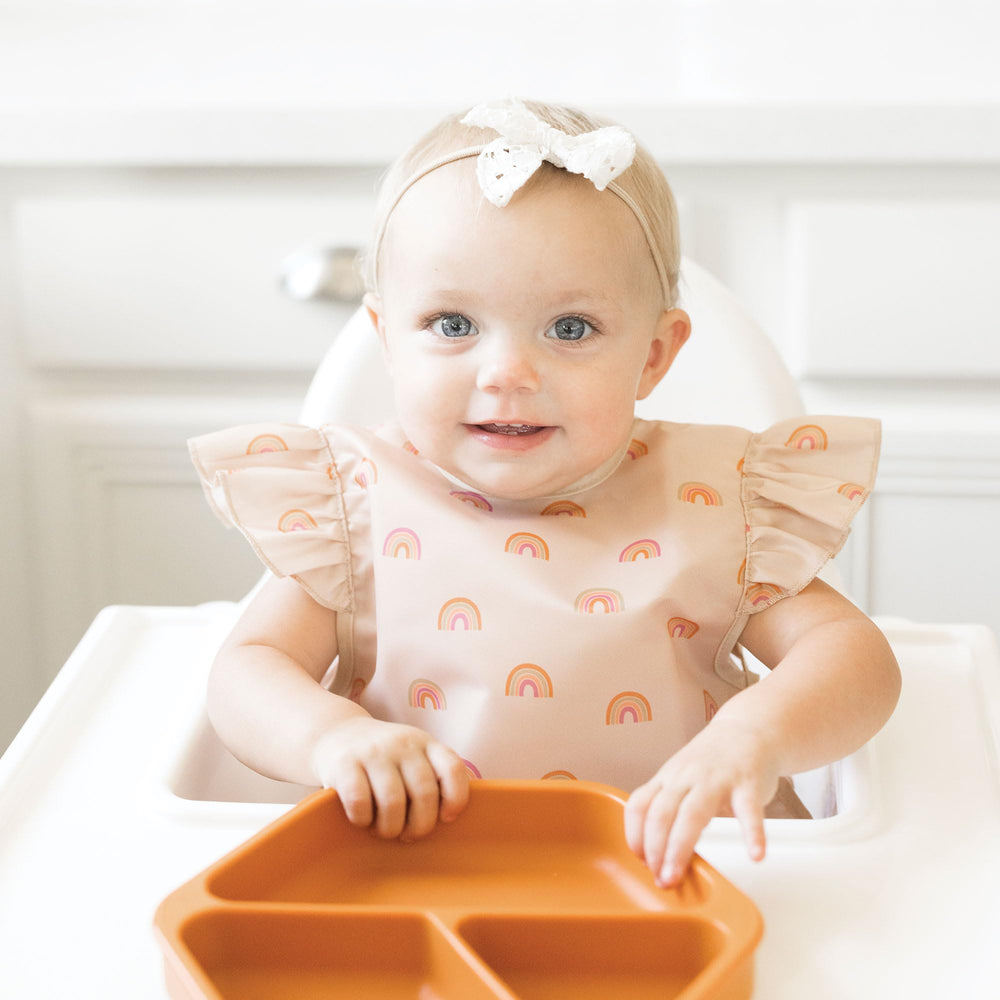 Tiny Twinkle Mess-Proof Bib adjustable straps demonstrate secure, comfortable fit for growing toddlers.